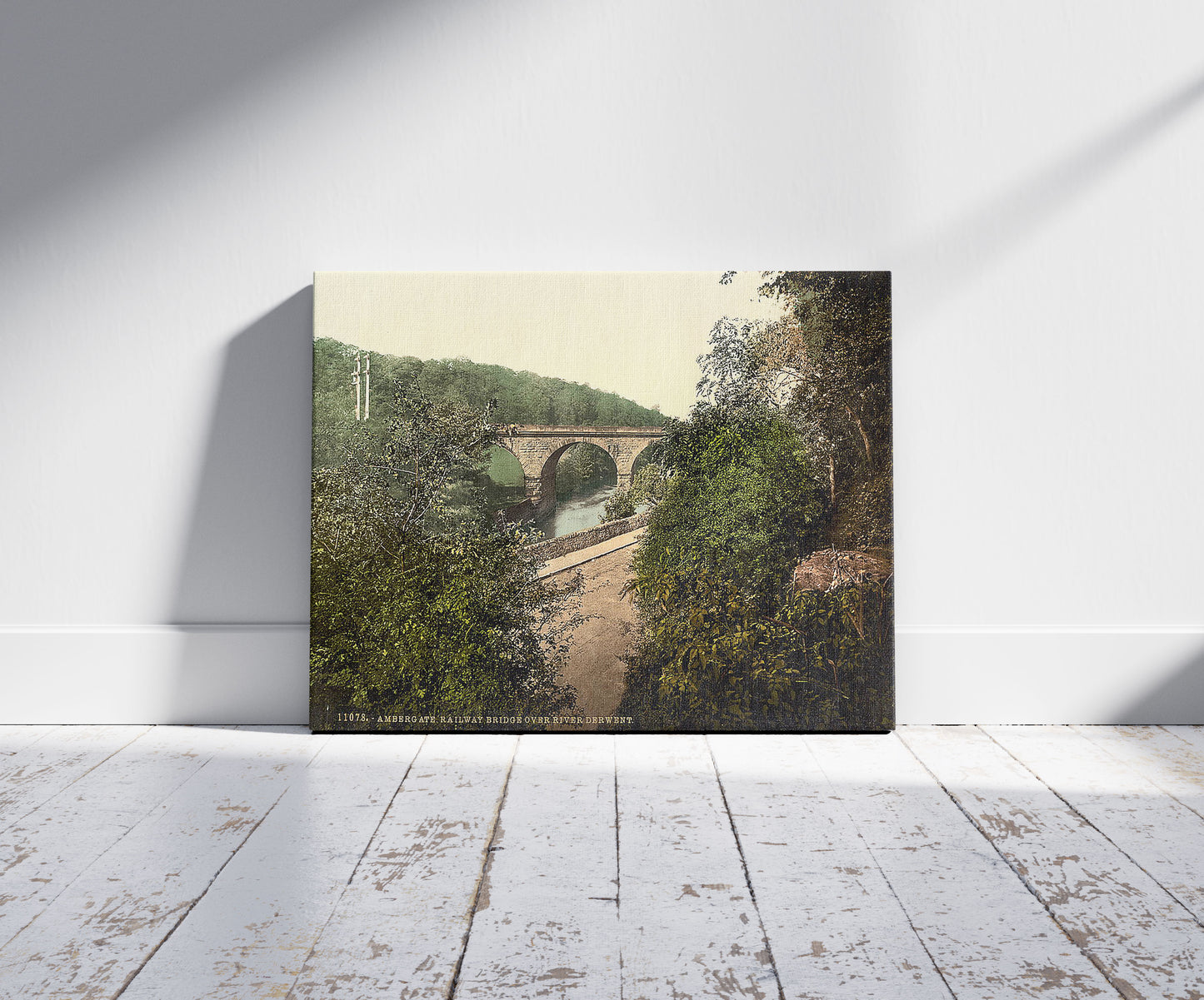 A picture of Ambergate, railway bridge over River Derwent, Derbyshire, England, a mockup of the print leaning against a wall