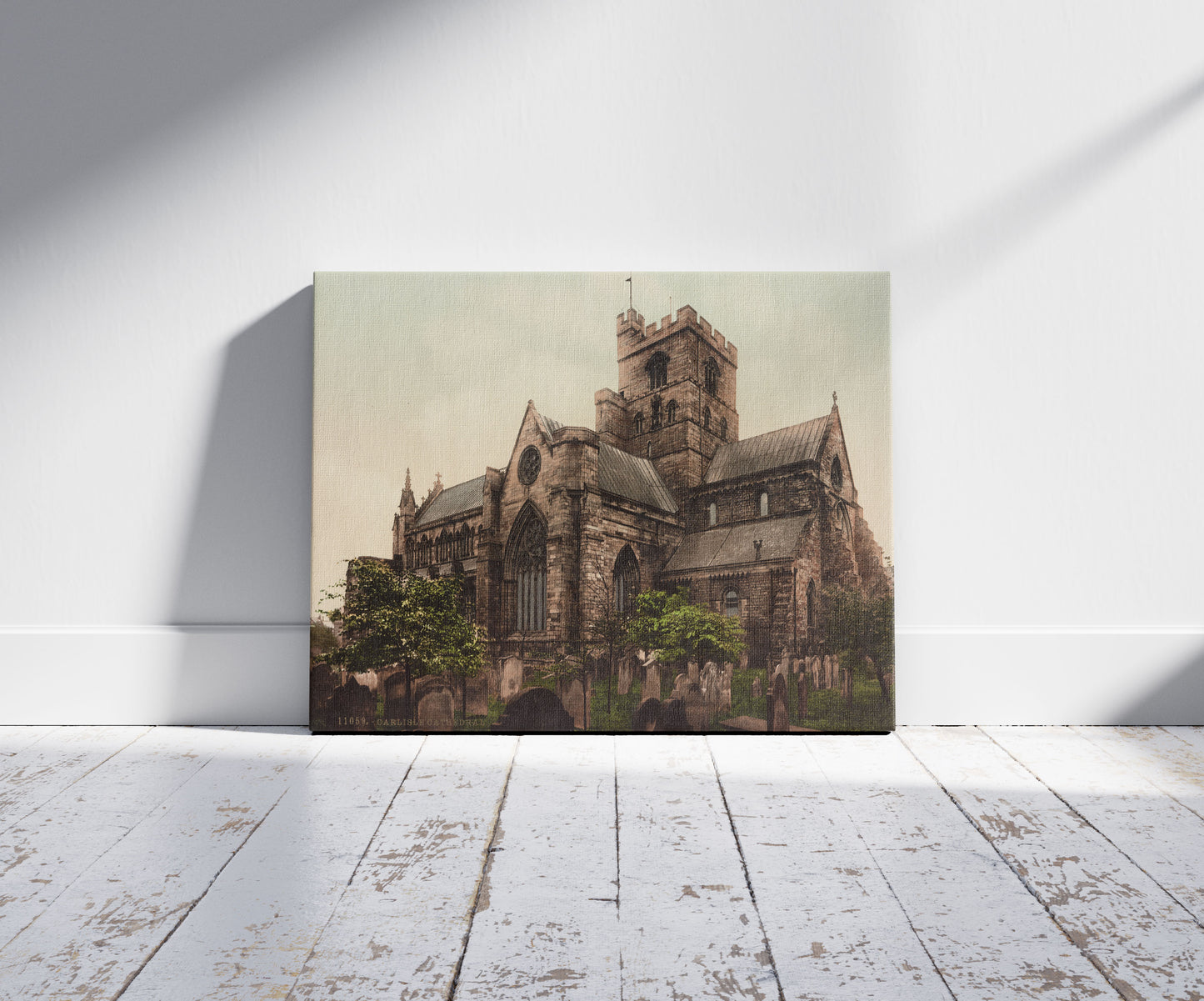 A picture of Carlisle Cathedral, a mockup of the print leaning against a wall