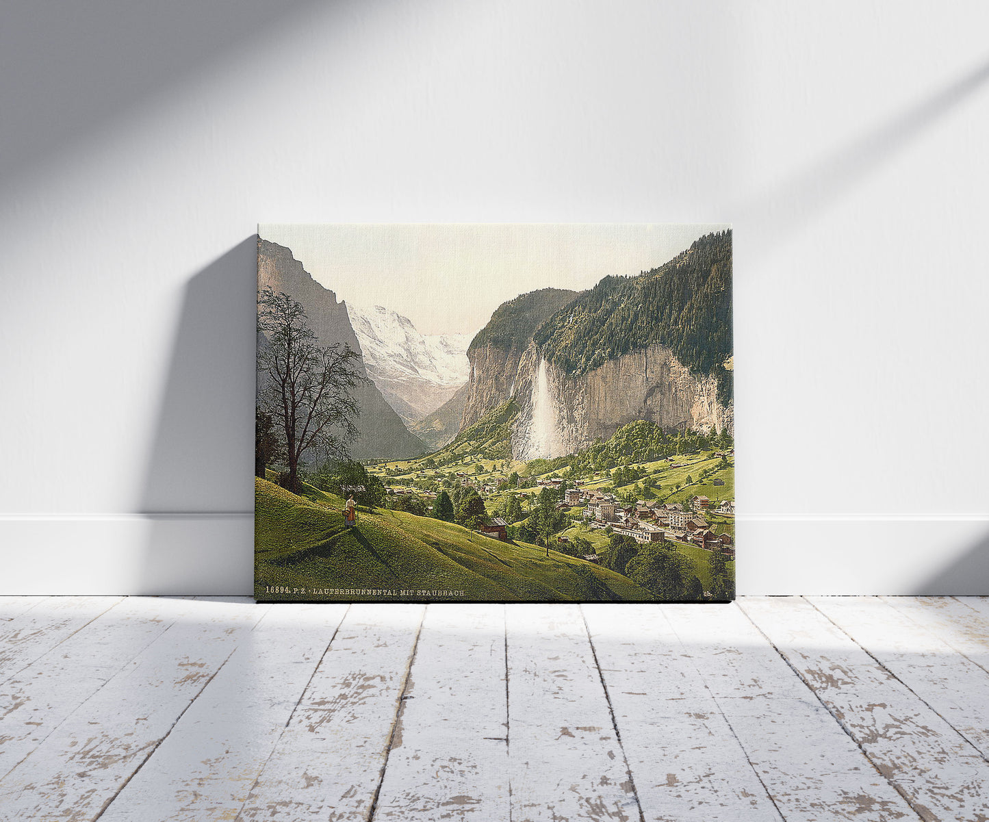 A picture of Lauterbrunnen Valley with Staubbach, Bernese Oberland, Switzerland, a mockup of the print leaning against a wall