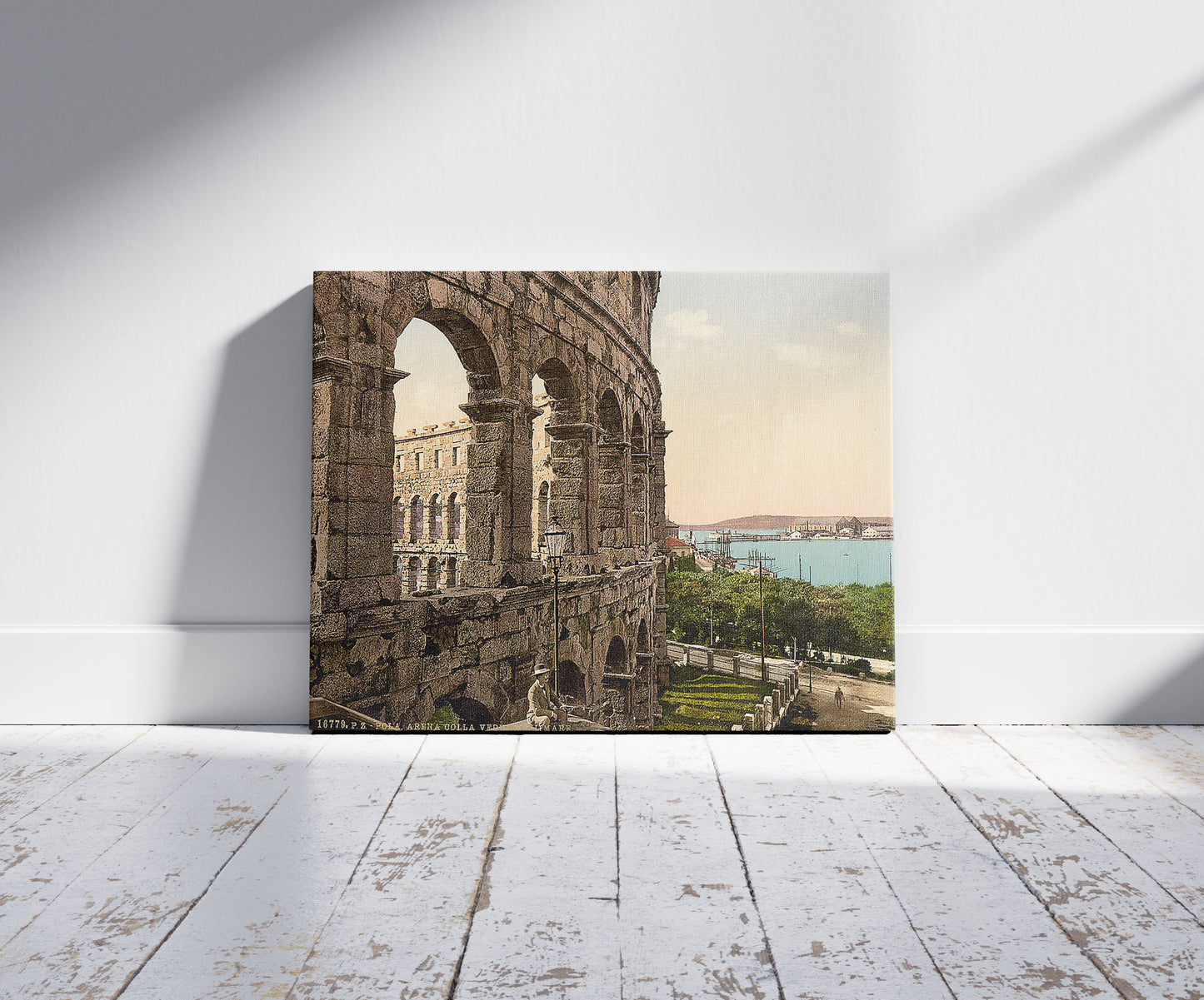 A picture of Pola, the arena, with view of the sea, Istria, Austro-Hungary, a mockup of the print leaning against a wall