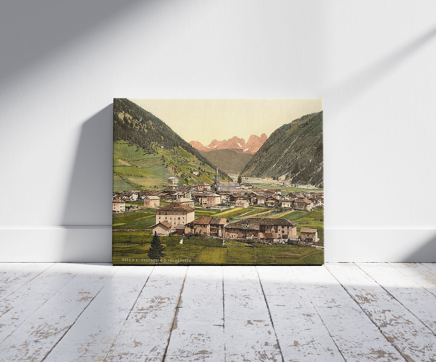 A picture of Predazzo, towards the Palagruppe, Tyrol, Austro-Hungary, a mockup of the print leaning against a wall