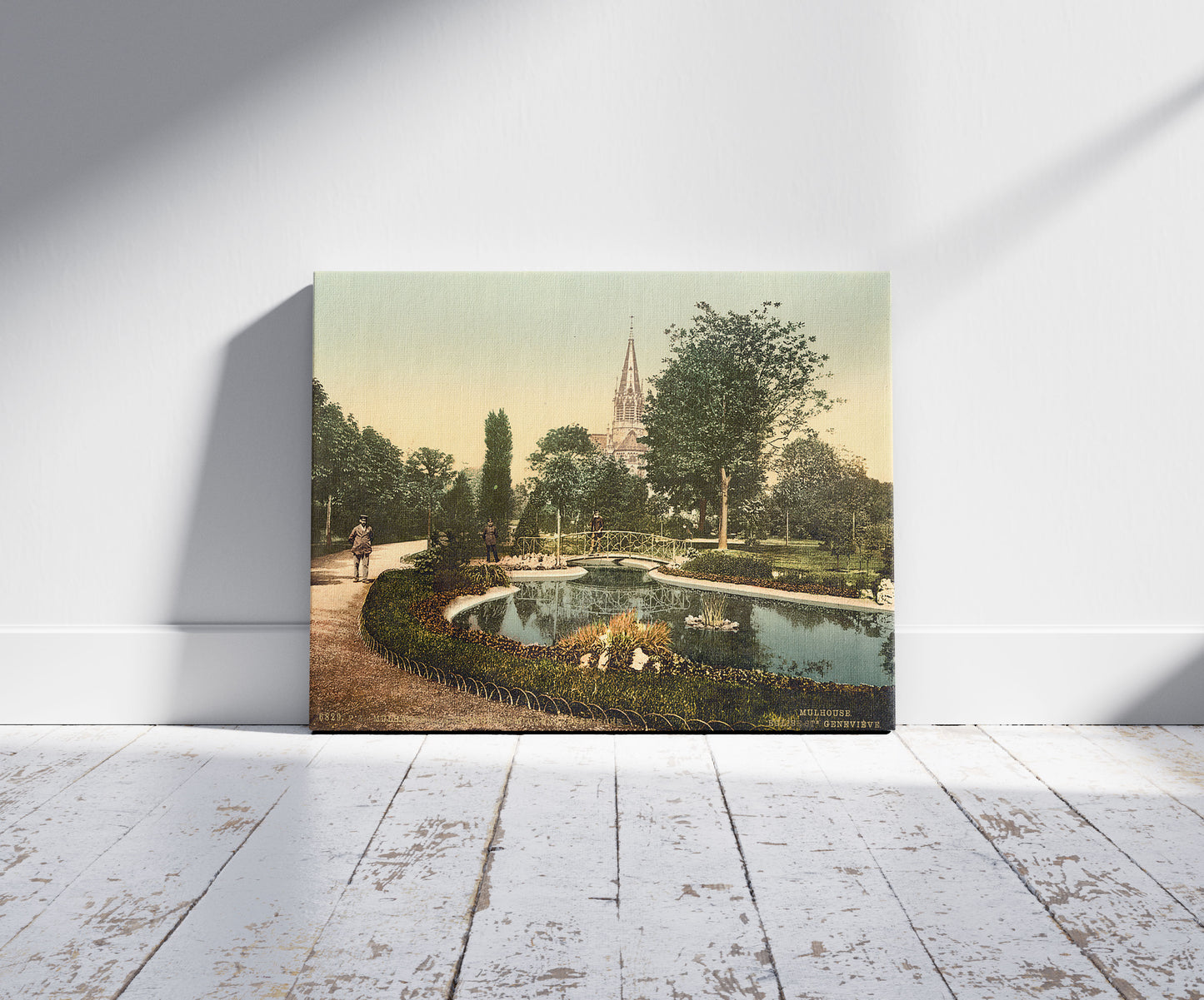 A picture of Promenade and St. Genieve Church, Mulhausen, Alsace Lorraine, Germany, a mockup of the print leaning against a wall