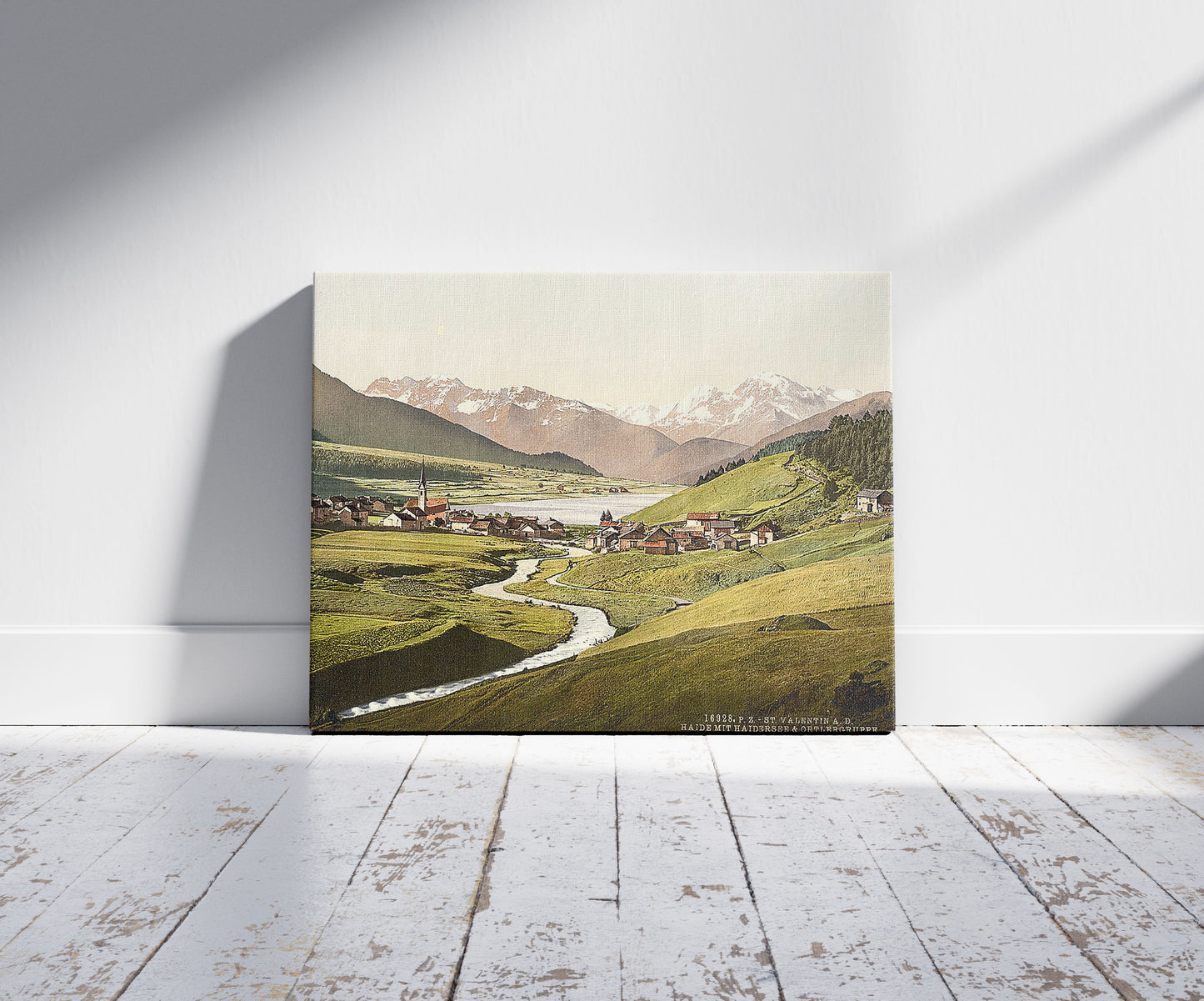 A picture of St. Valentine on the Danube, Haide with Haidersee and Ortergruppe, Tyrol, Austro-Hungary, a mockup of the print leaning against a wall