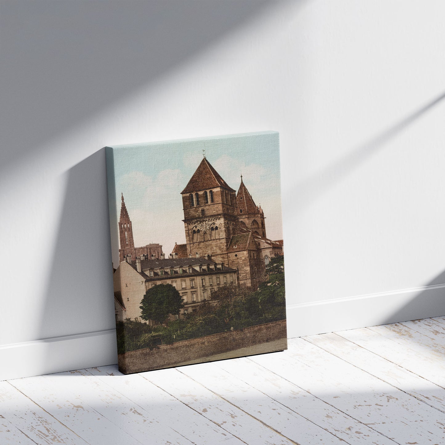 A picture of Strasbourg. L'Eglise St. Thomas et la Cathédrale. Strassburg Thomaskirche & Münster., a mockup of the print leaning against a wall