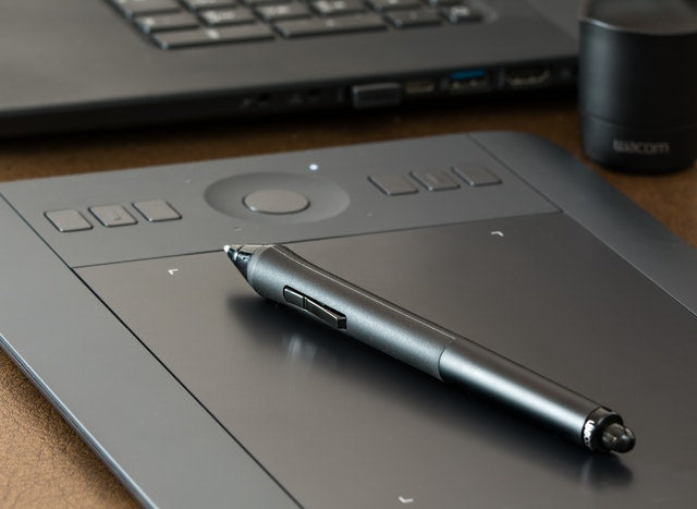 Photo of a pen resting on a digital tablet.
