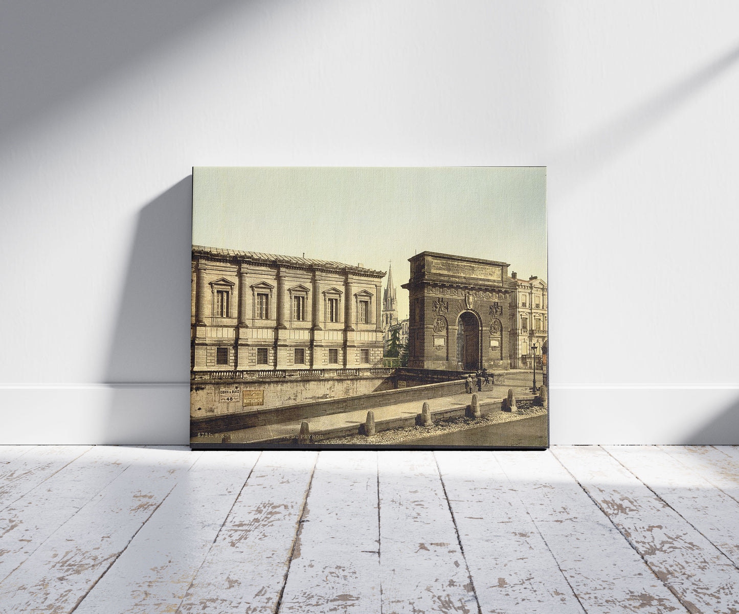 A picture of Beyron (i.e., Peyrou) Gate, Montpelier, France, a mockup of the print leaning against a wall