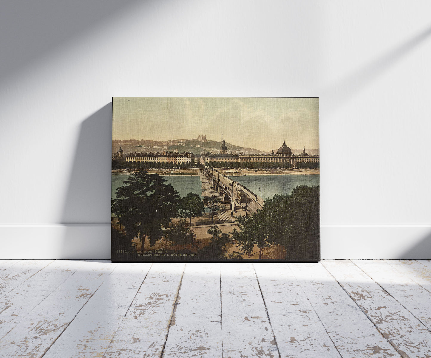 A picture of Bridge of the Guillotiere and the Hotel de Dieu, Lyons, France, a mockup of the print leaning against a wall