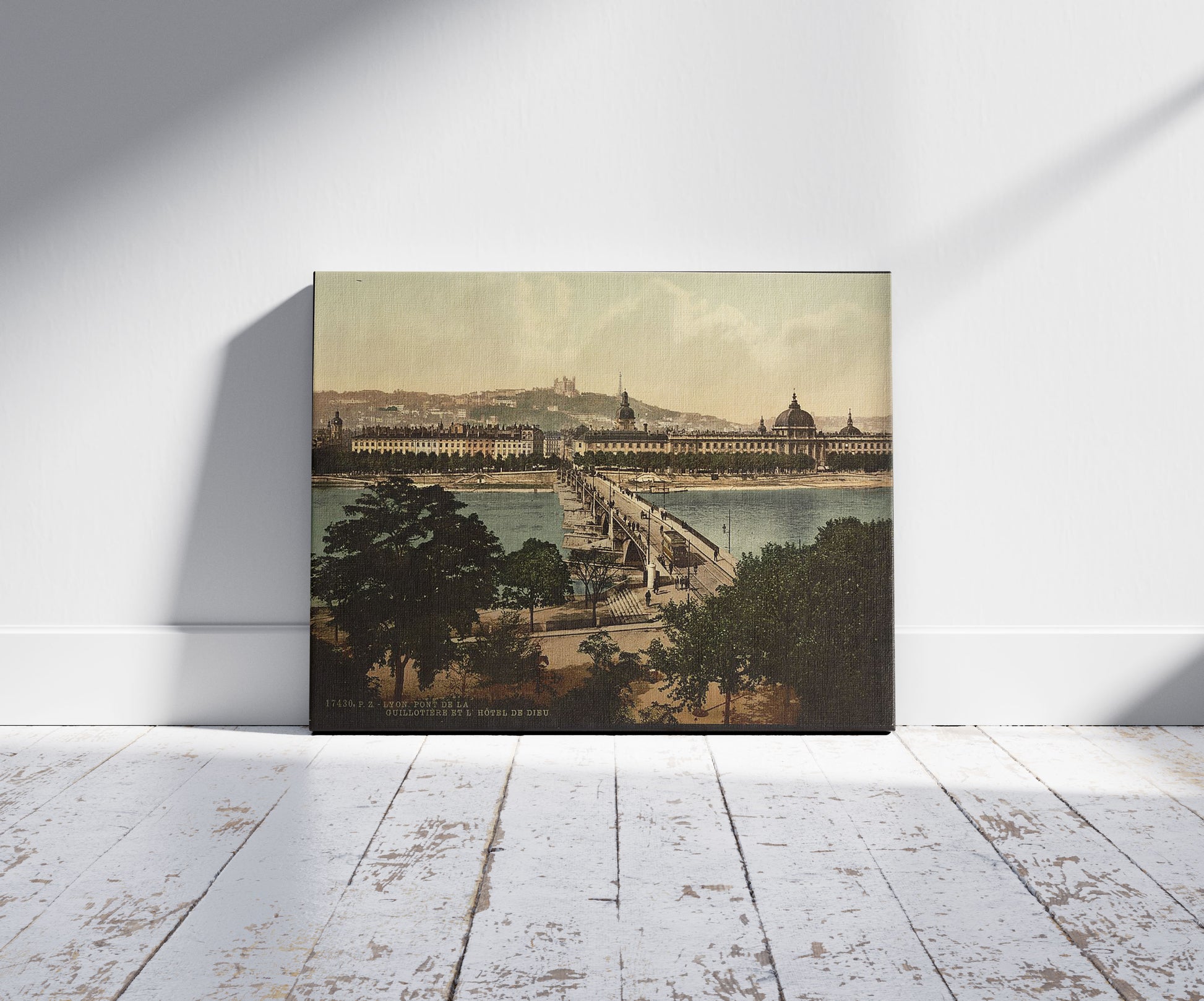 A picture of Bridge of the Guillotiere and the Hotel de Dieu, Lyons, France, a mockup of the print leaning against a wall