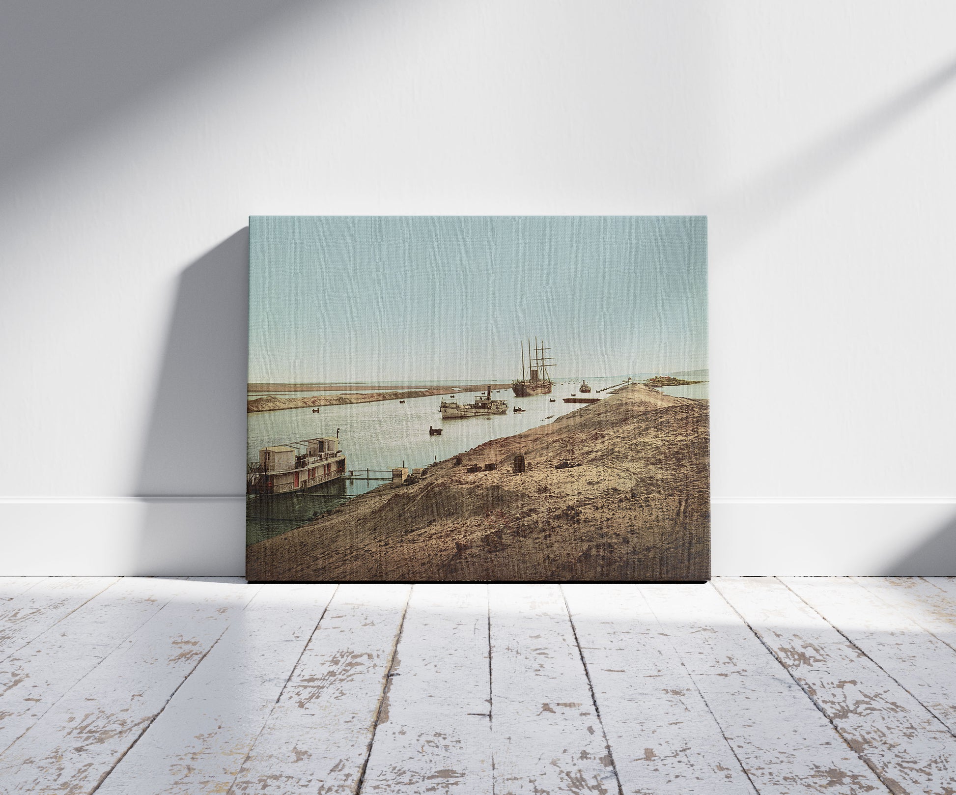 A picture of Canal de Suez, entrée au Lac Salé, a mockup of the print leaning against a wall