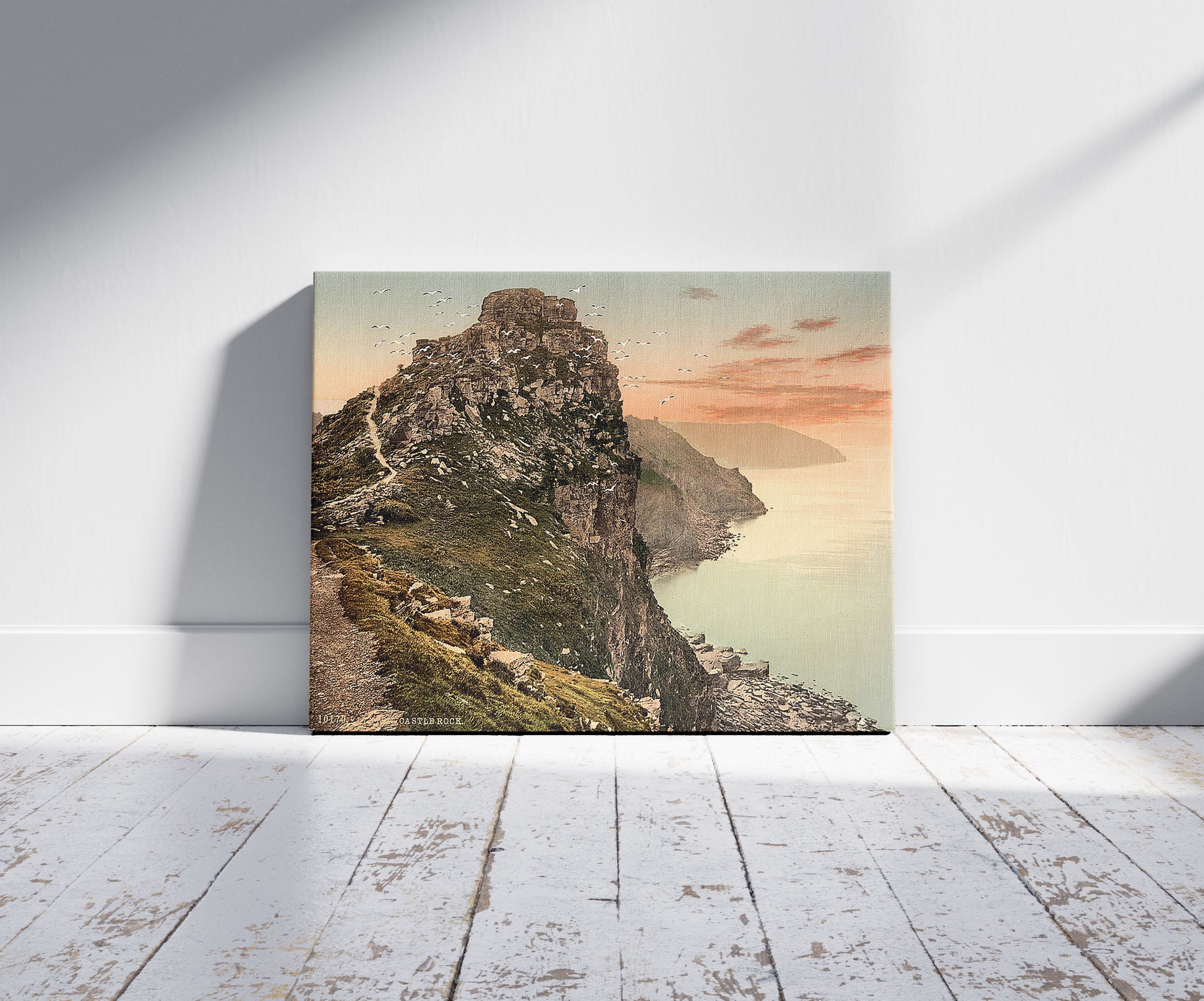 A picture of Castle Rock in the Valley of Rocks, Lynton and Lynmouth, England, a mockup of the print leaning against a wall