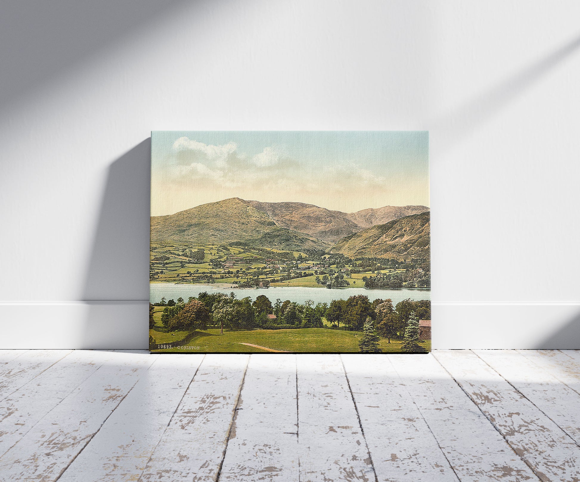 A picture of Coniston, Lake District, England, a mockup of the print leaning against a wall