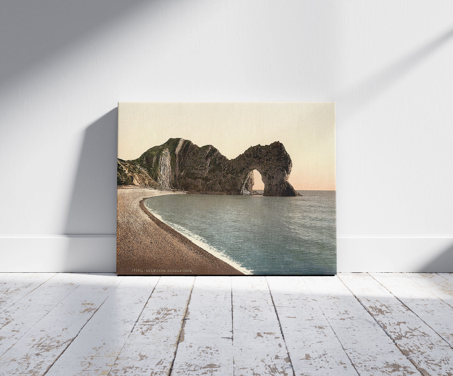 A picture of Durdle Door, Lulworth, England, a mockup of the print leaning against a wall