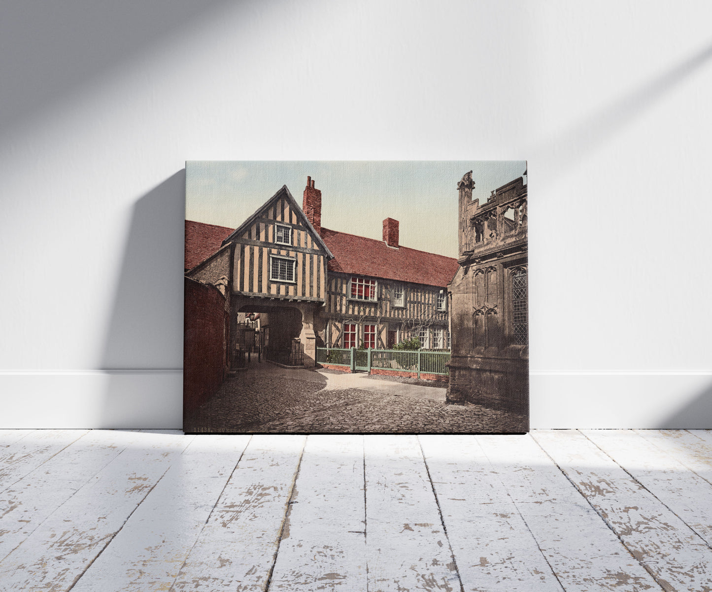 A picture of Evesham, Abbot Reginald's gateway & old vicarage, a mockup of the print leaning against a wall