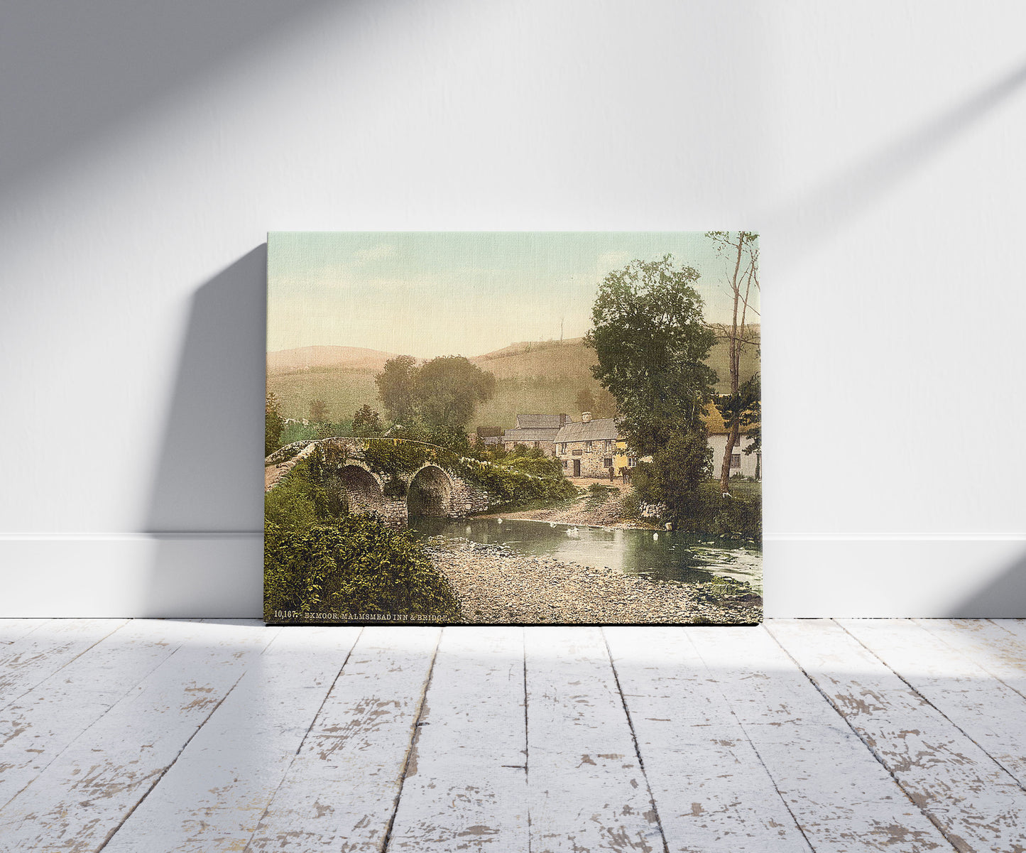 A picture of Exmoor, Malmsmead Inn and bridge, Doone Valley, Lynton and Lynmouth, England, a mockup of the print leaning against a wall