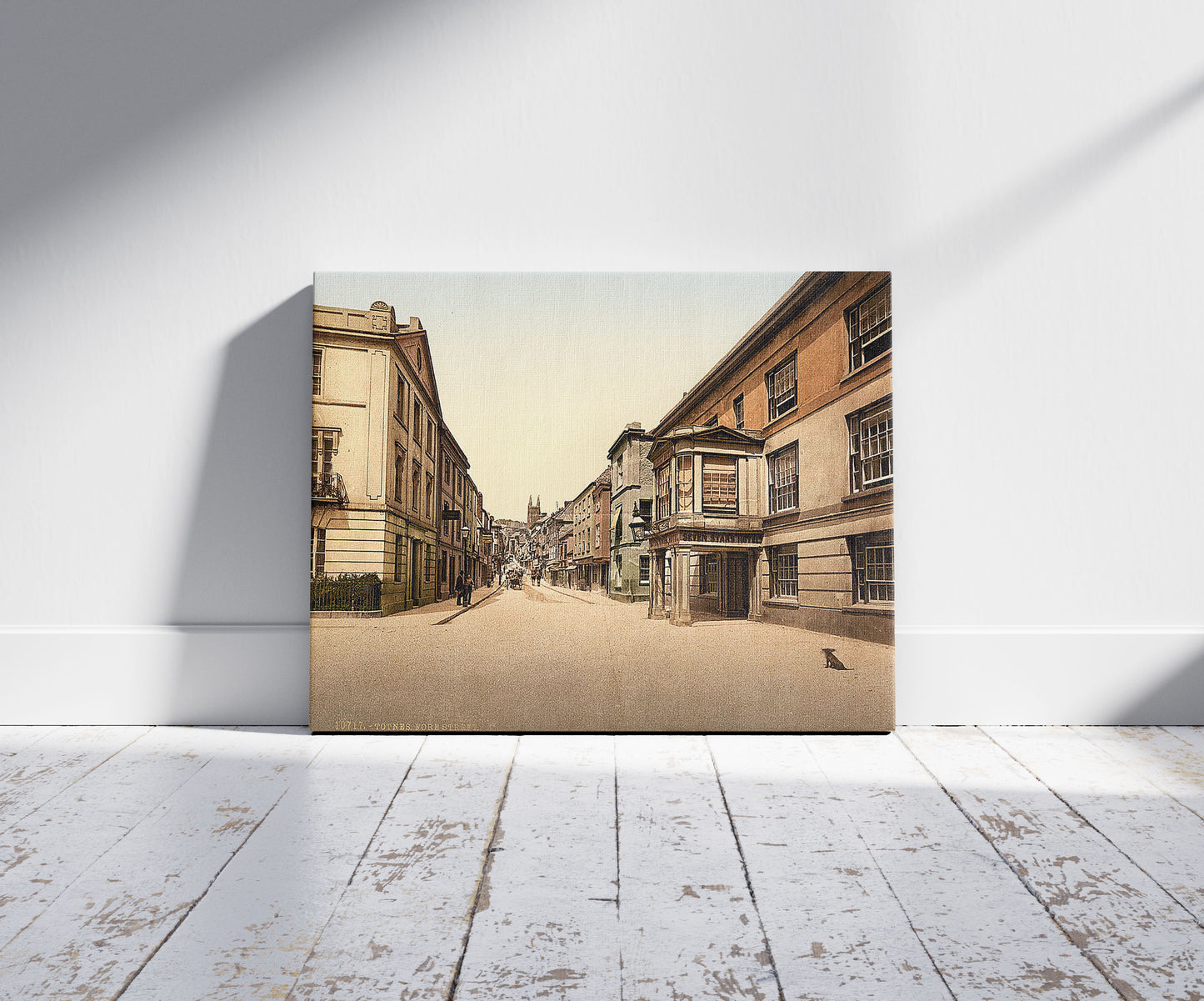 A picture of Fore Street, Totnes, England, a mockup of the print leaning against a wall