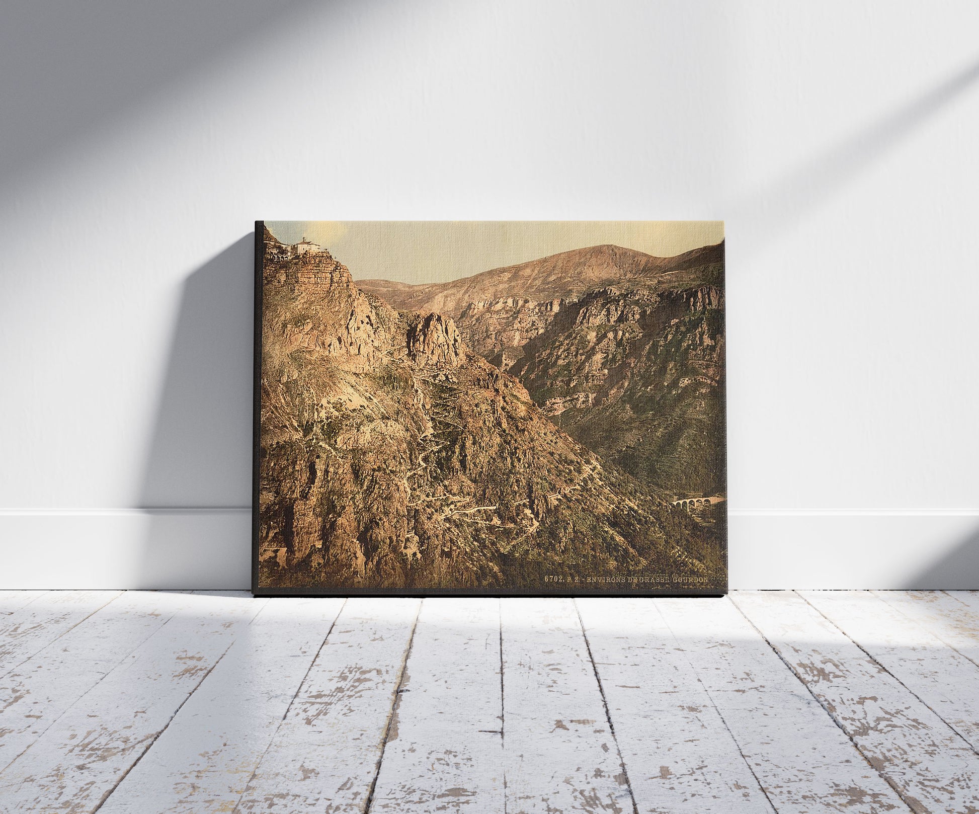 A picture of Gourdon, Grasse, France, a mockup of the print leaning against a wall