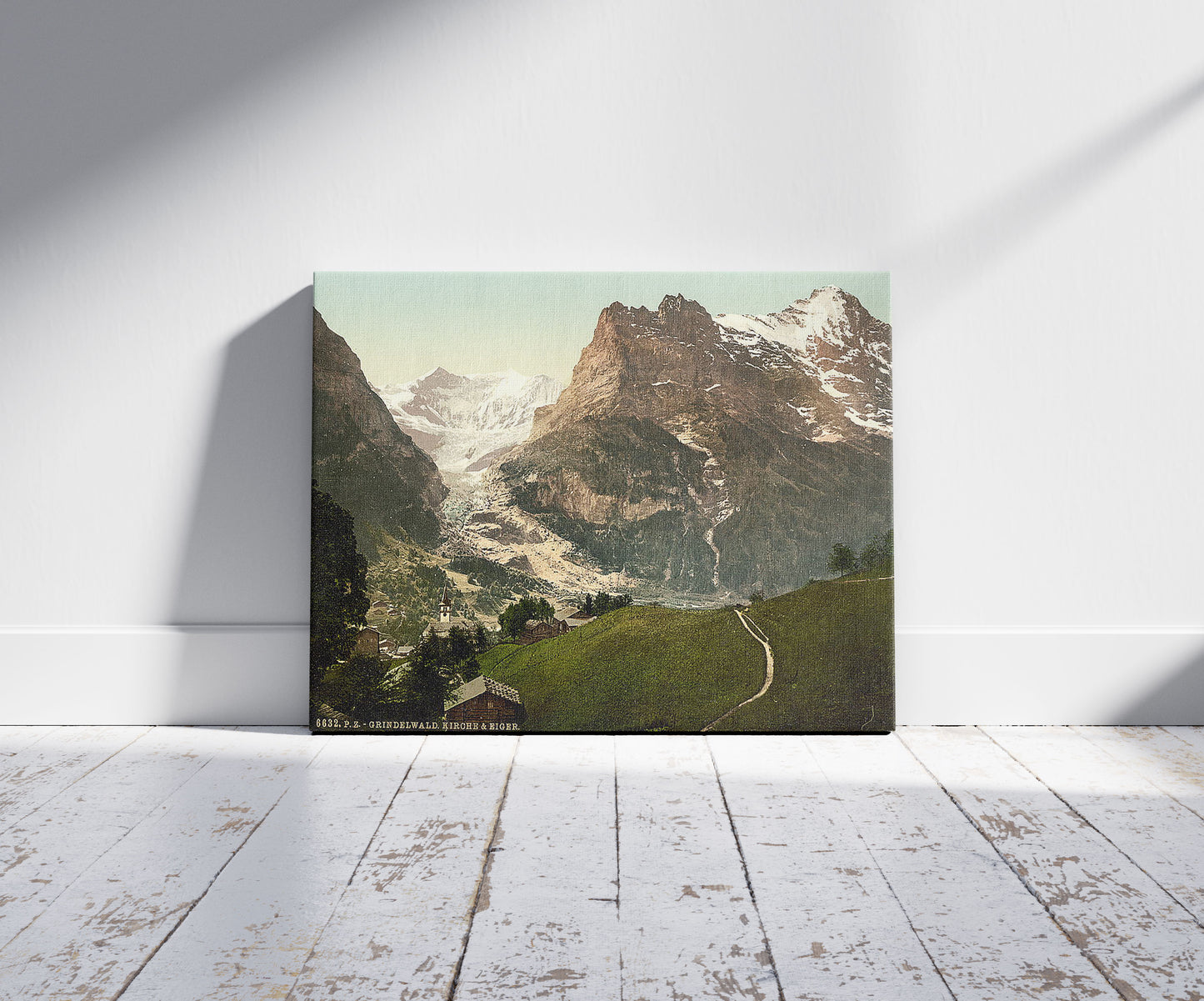 A picture of Grindelwald, church and Eiger, Bernese Oberland, Switzerland, a mockup of the print leaning against a wall