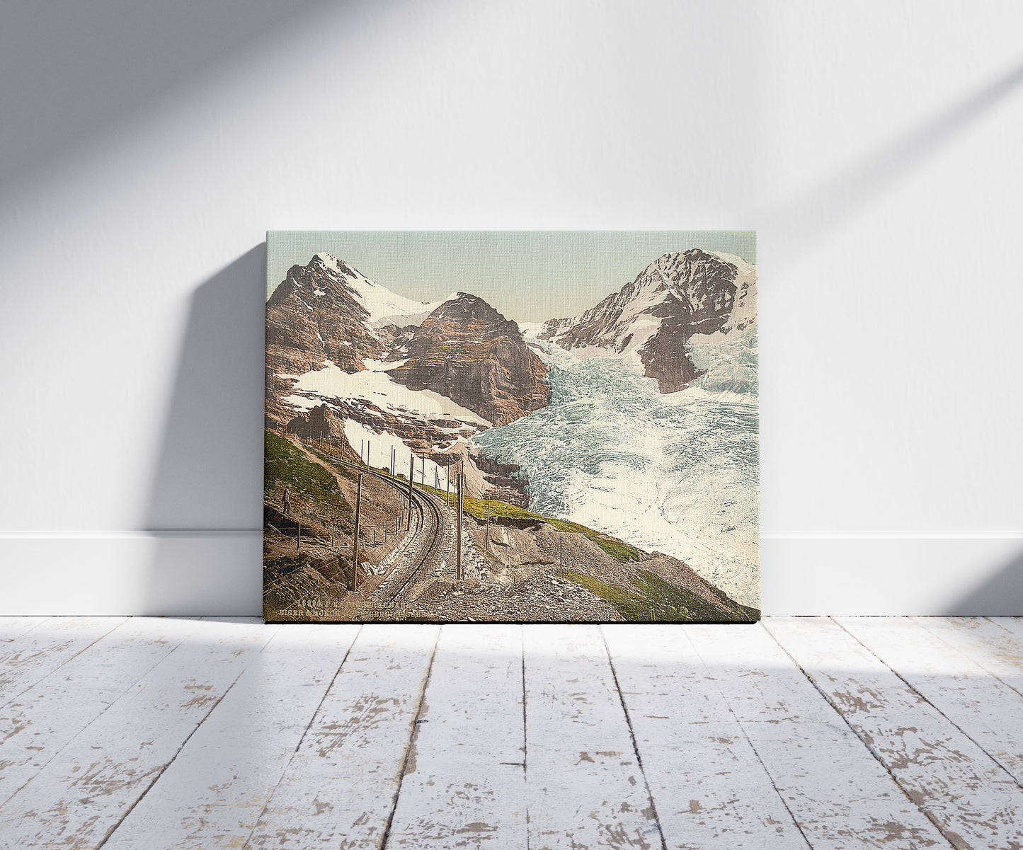 A picture of Jungfrau, railroad, Eiger and Monch, with Eiger Glacier, Bernese Oberland, Switzerland, a mockup of the print leaning against a wall