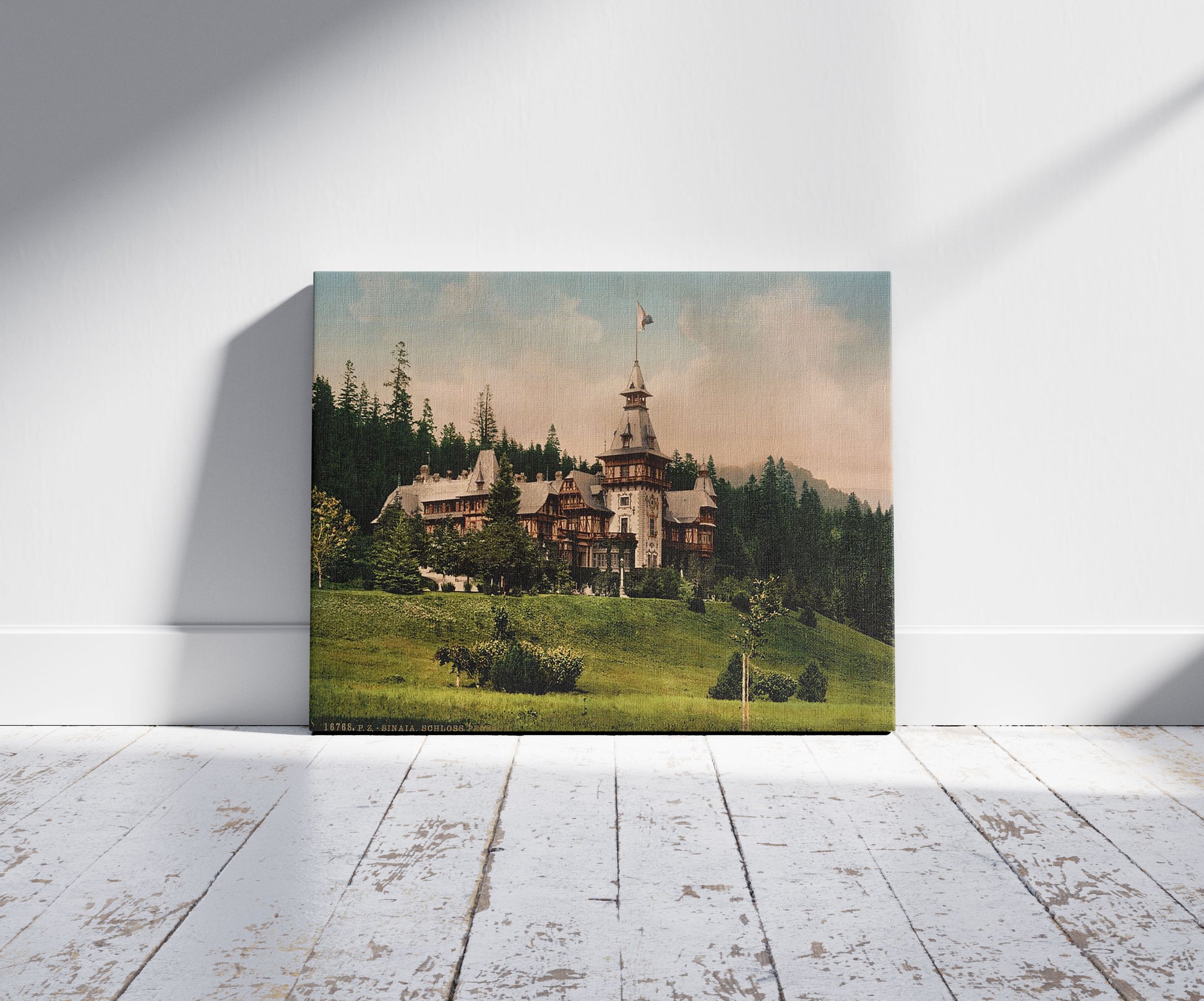 A picture of Pelesch (i.e., Peles) Castle, Sinaia, Roumania, a mockup of the print leaning against a wall