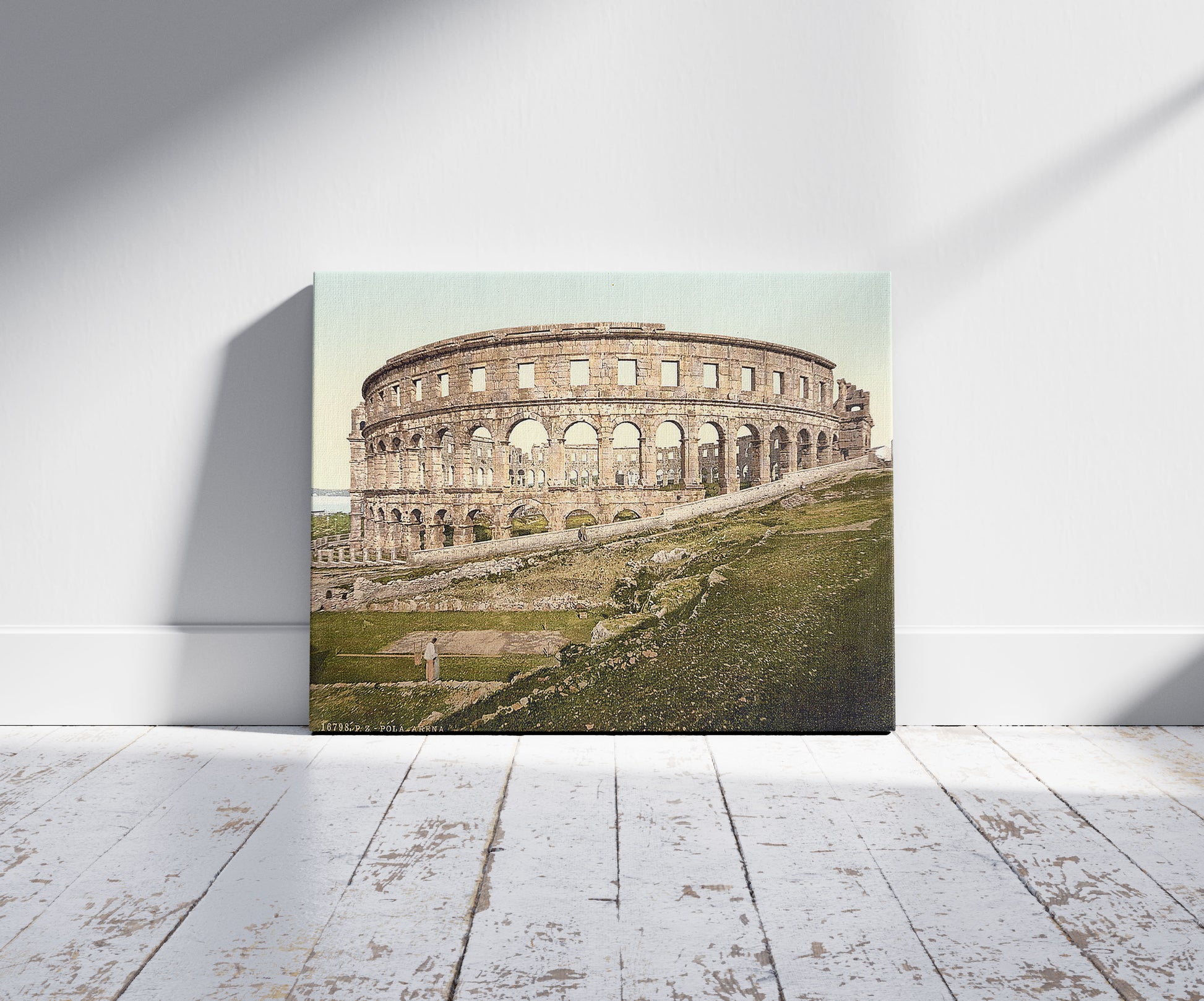A picture of Pola, the arena, Istria, Austro-Hungary, a mockup of the print leaning against a wall