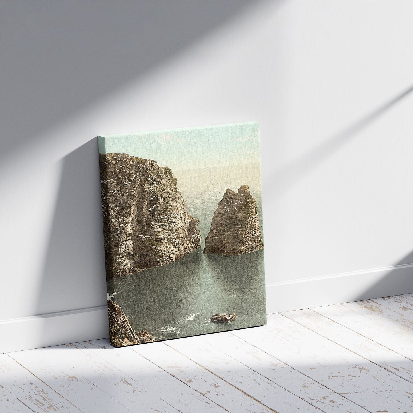 A picture of Port St. Mary, Sugar Loaf Rock, Isle of Man, a mockup of the print leaning against a wall