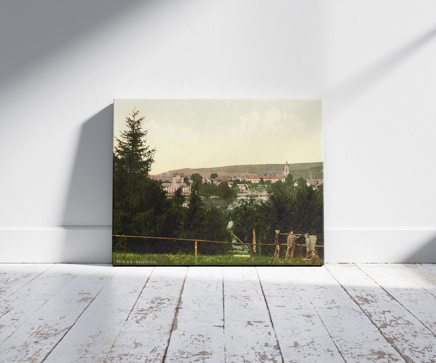 A picture of Salzungen (i.e., Bad Salzungen), with the castle, from Seeberg, Thuringia, Germany, a mockup of the print leaning against a wall