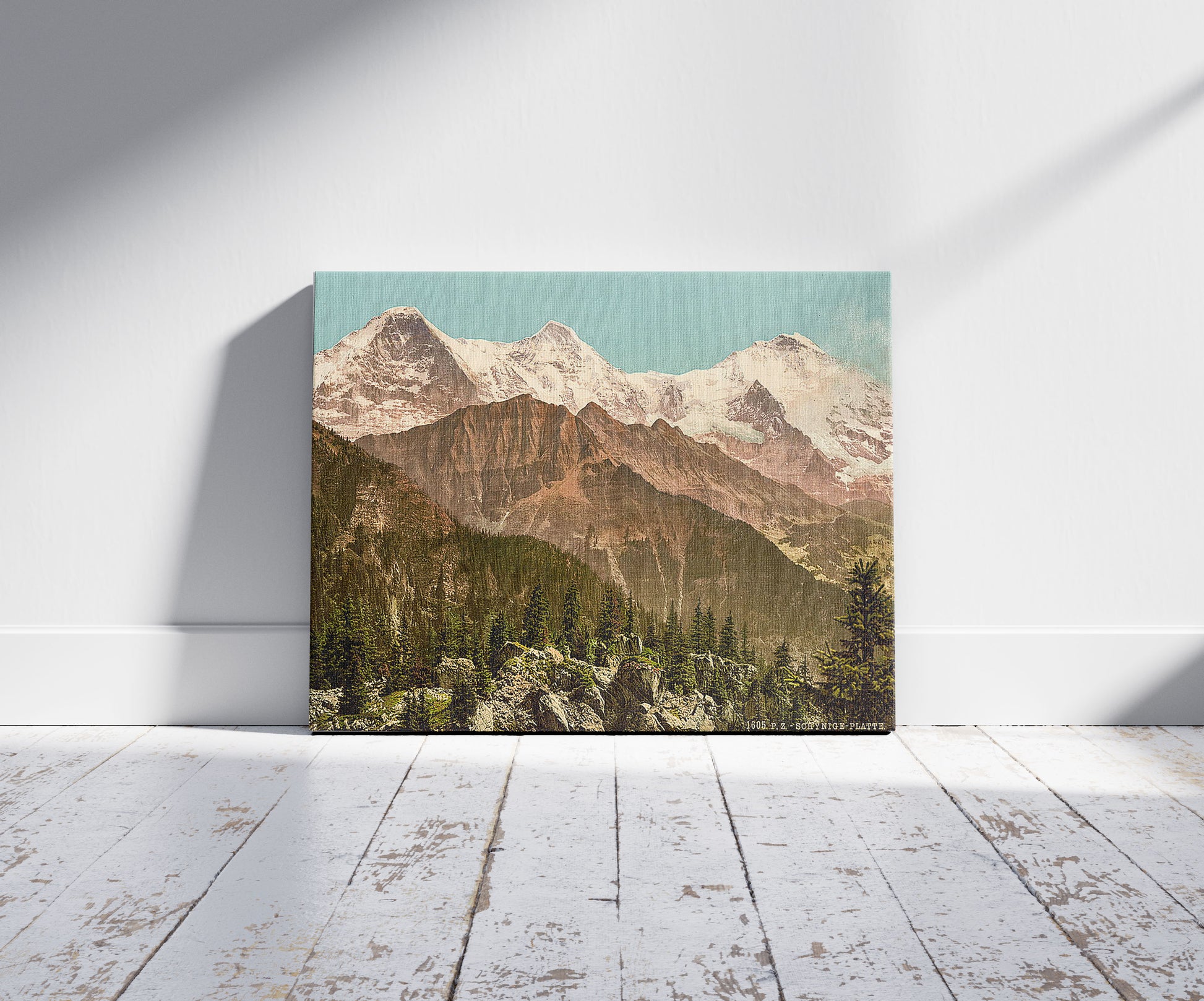 A picture of Schynige Platte, Eiger, Monch and Jungfrau, Bernese Oberland, Switzerland, a mockup of the print leaning against a wall