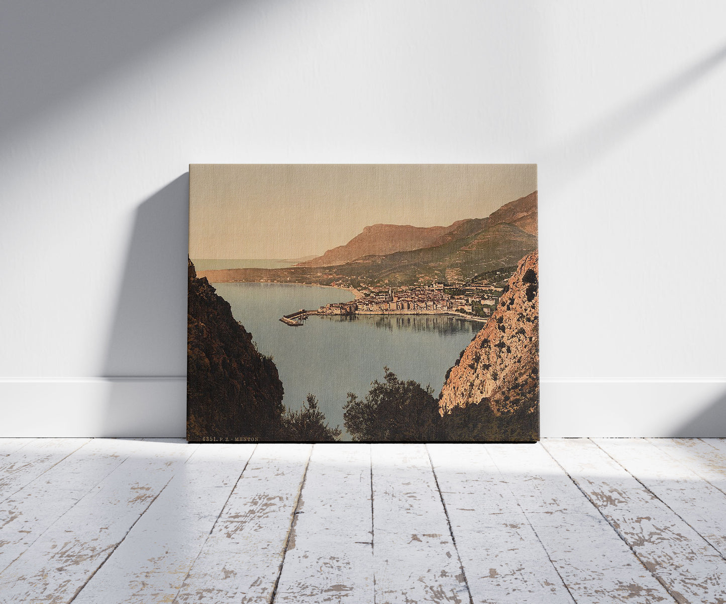 A picture of Seen from the cliffs, Mentone, Riviera , a mockup of the print leaning against a wall