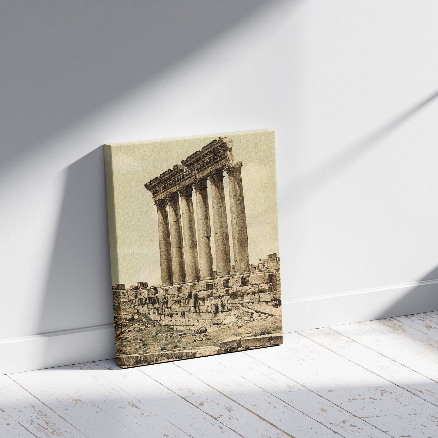 A picture of Temple of the Sun, side view, Baalbek, Holy Land, (i.e., Ba'labakk, Lebanon), a mockup of the print leaning against a wall