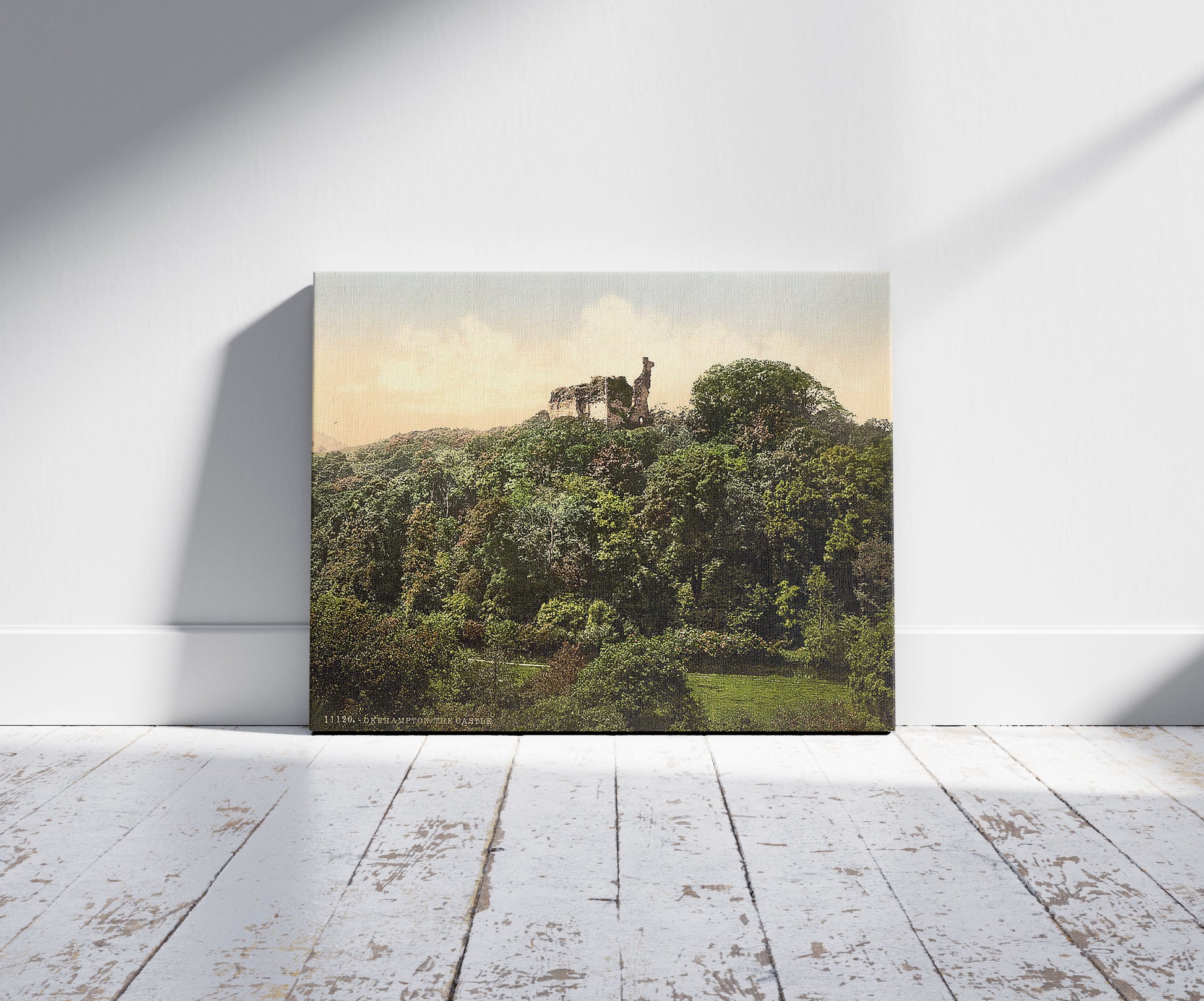 A picture of The castle, Okehampton, England, a mockup of the print leaning against a wall