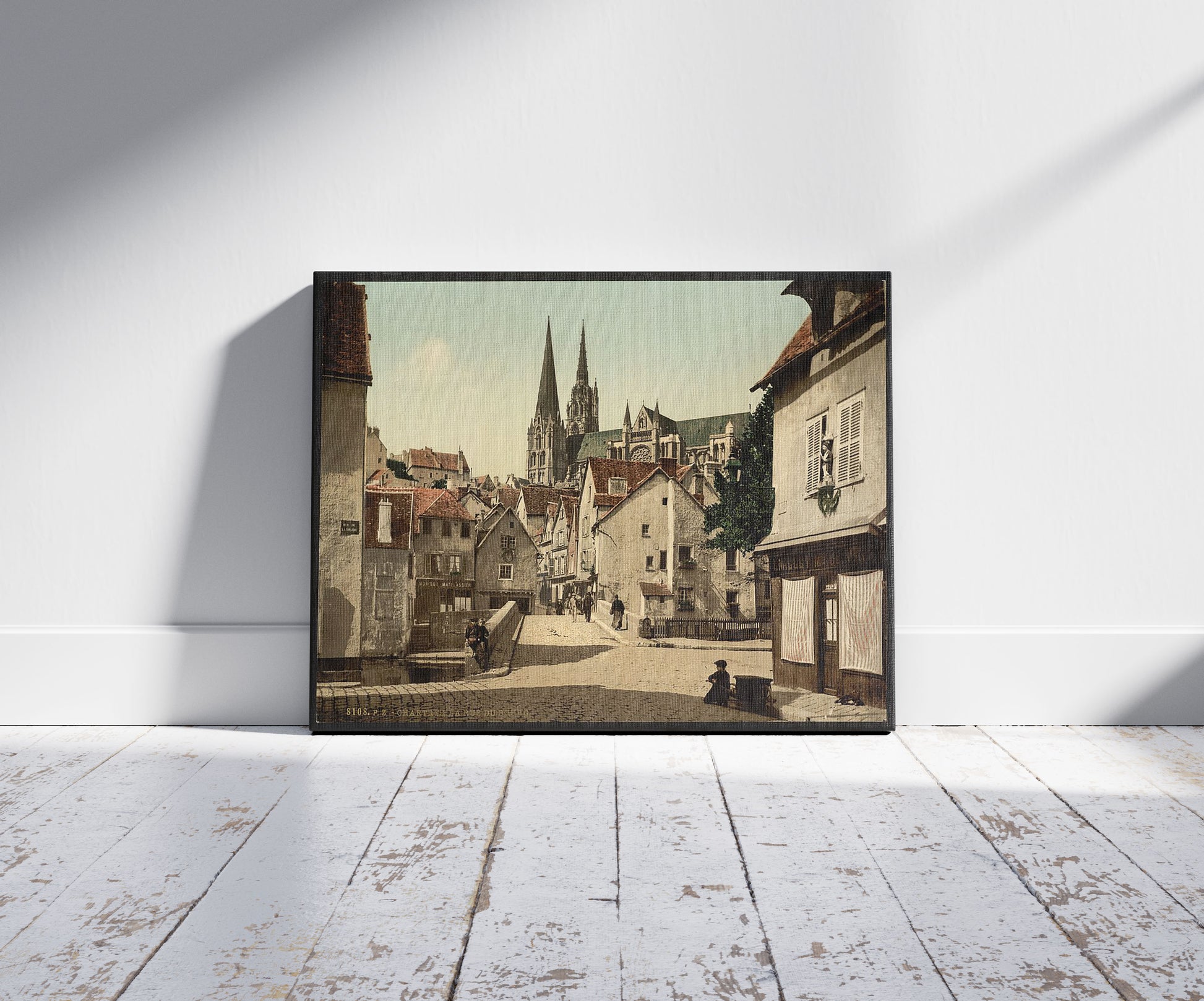 A picture of The market street, Chartres, France, a mockup of the print leaning against a wall