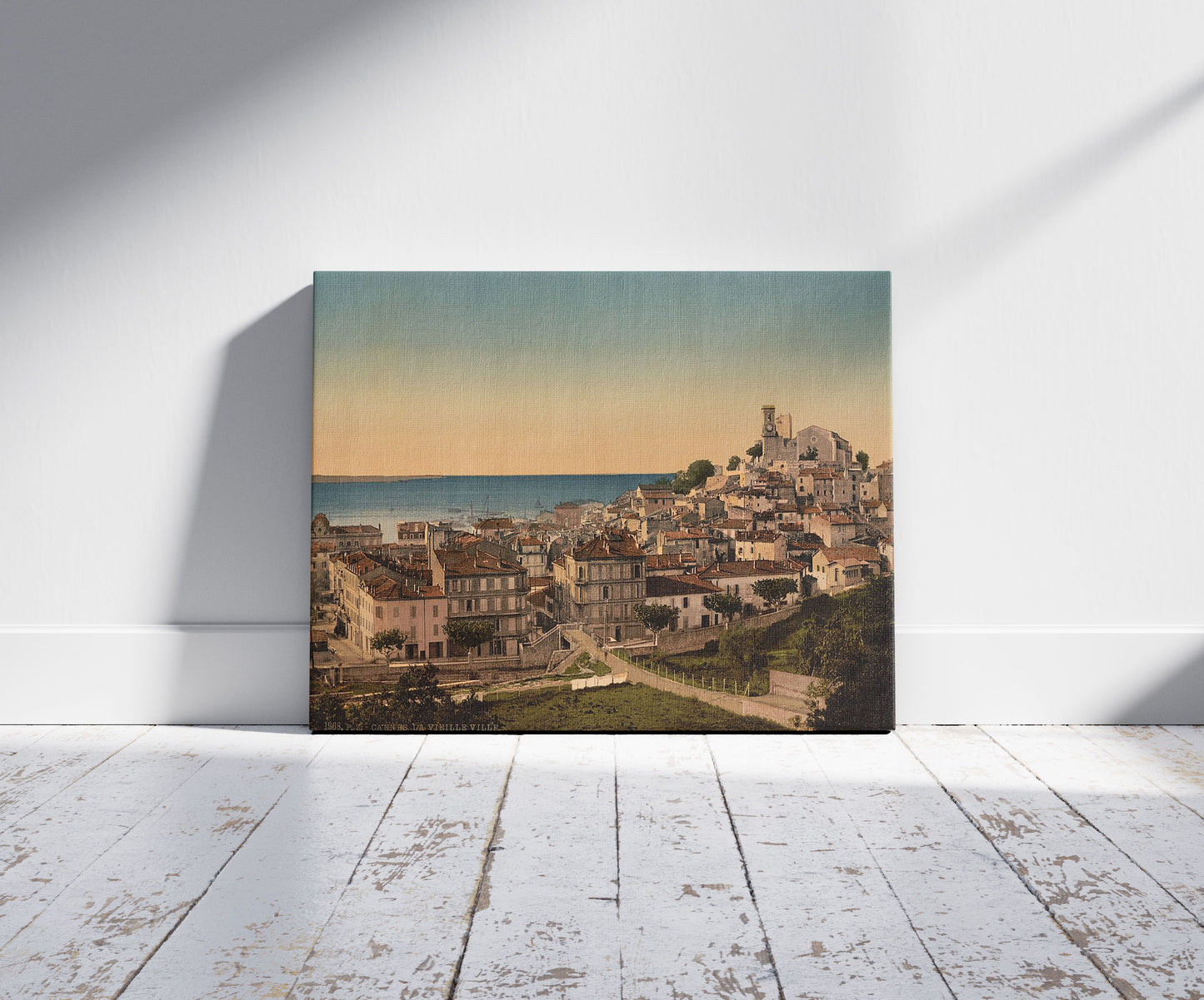 A picture of The old town, Cannes, Riviera, a mockup of the print leaning against a wall