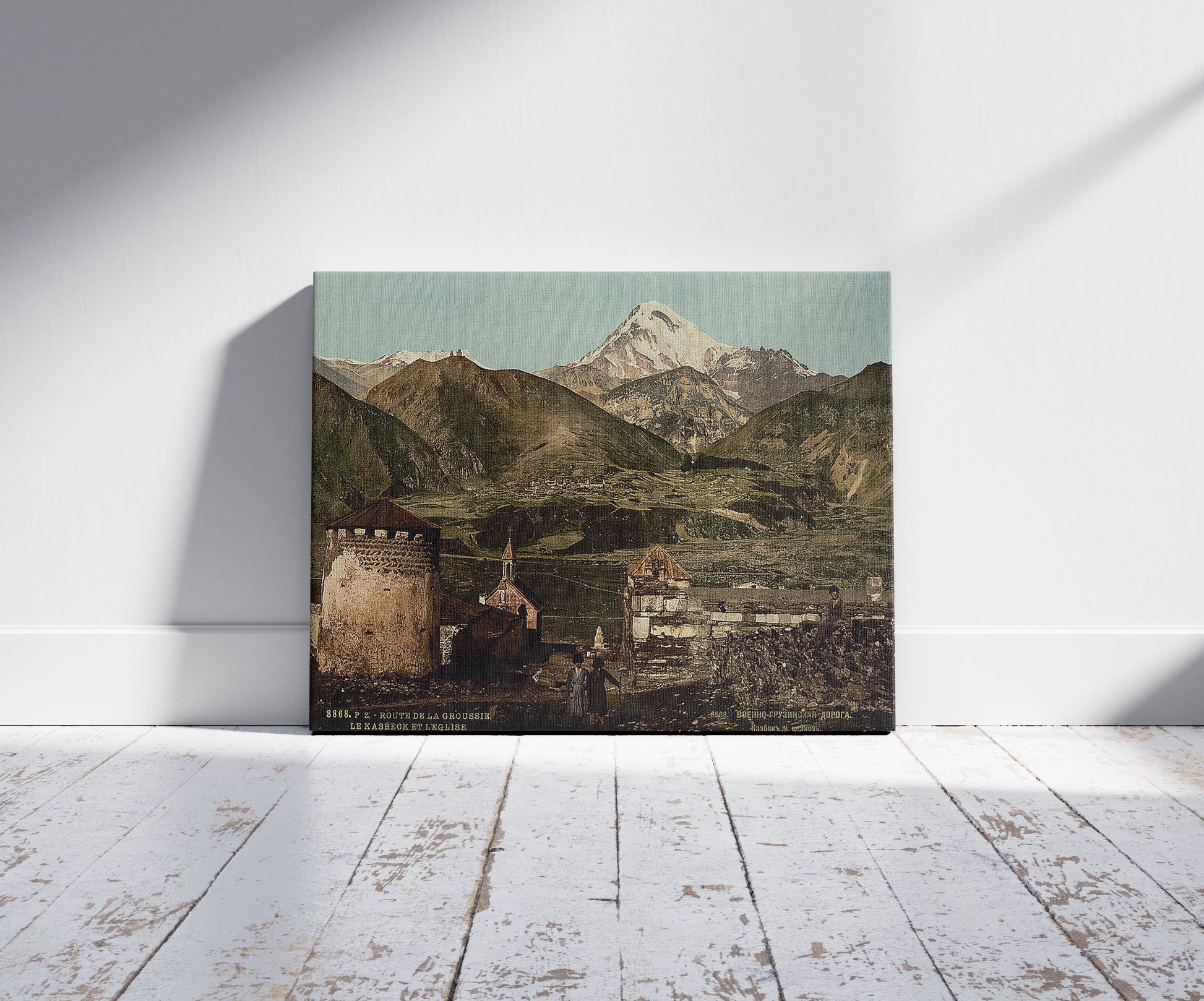 A picture of The road, the kasbeck and the church, Groussie, Georgia, a mockup of the print leaning against a wall