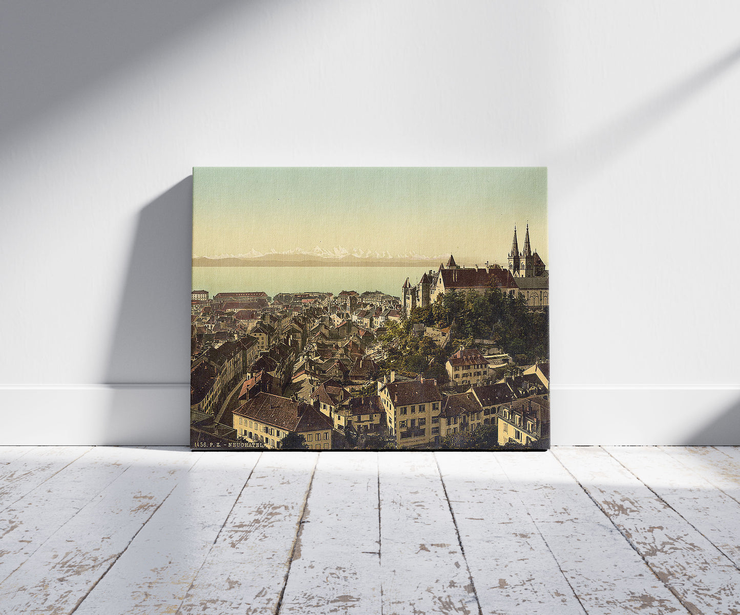A picture of The town, general view showing the alps, Neuchatel, and the castle, Switzerland, a mockup of the print leaning against a wall