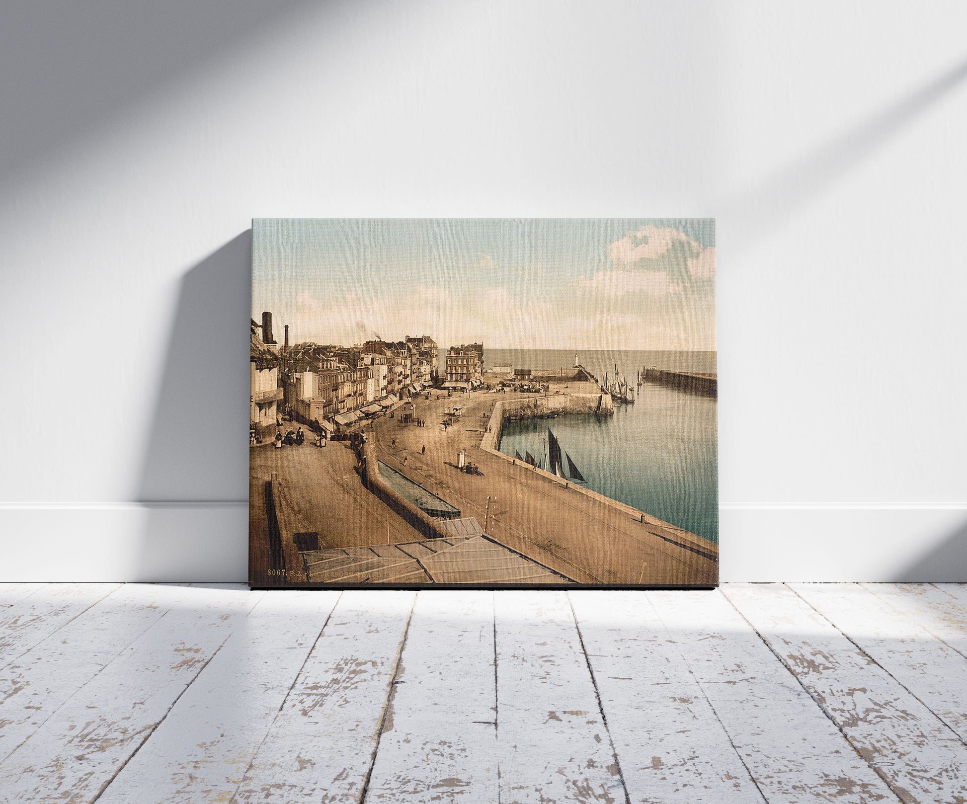 A picture of The wharf from the harbor, Tréport, France, a mockup of the print leaning against a wall