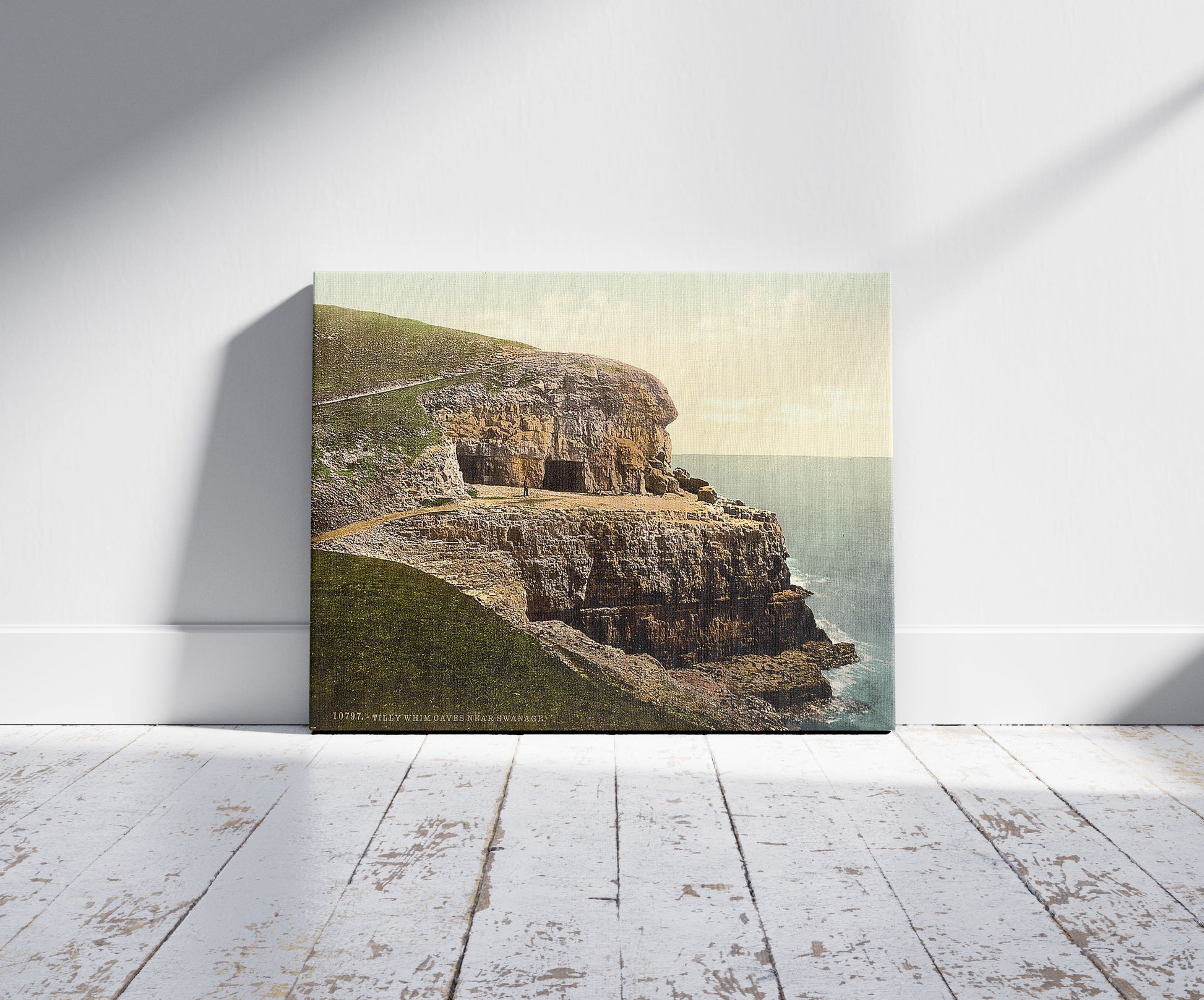 A picture of Tilly Whim Caves, Swanage, England, a mockup of the print leaning against a wall