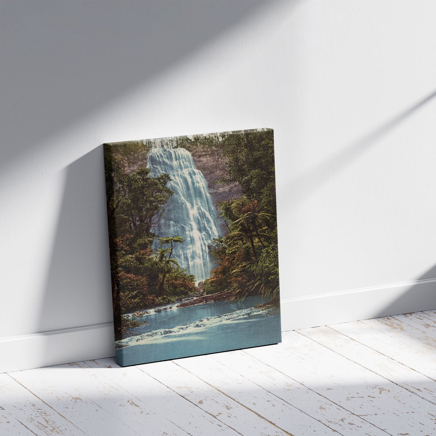 A picture of Waitakerei Upper Falls, a mockup of the print leaning against a wall