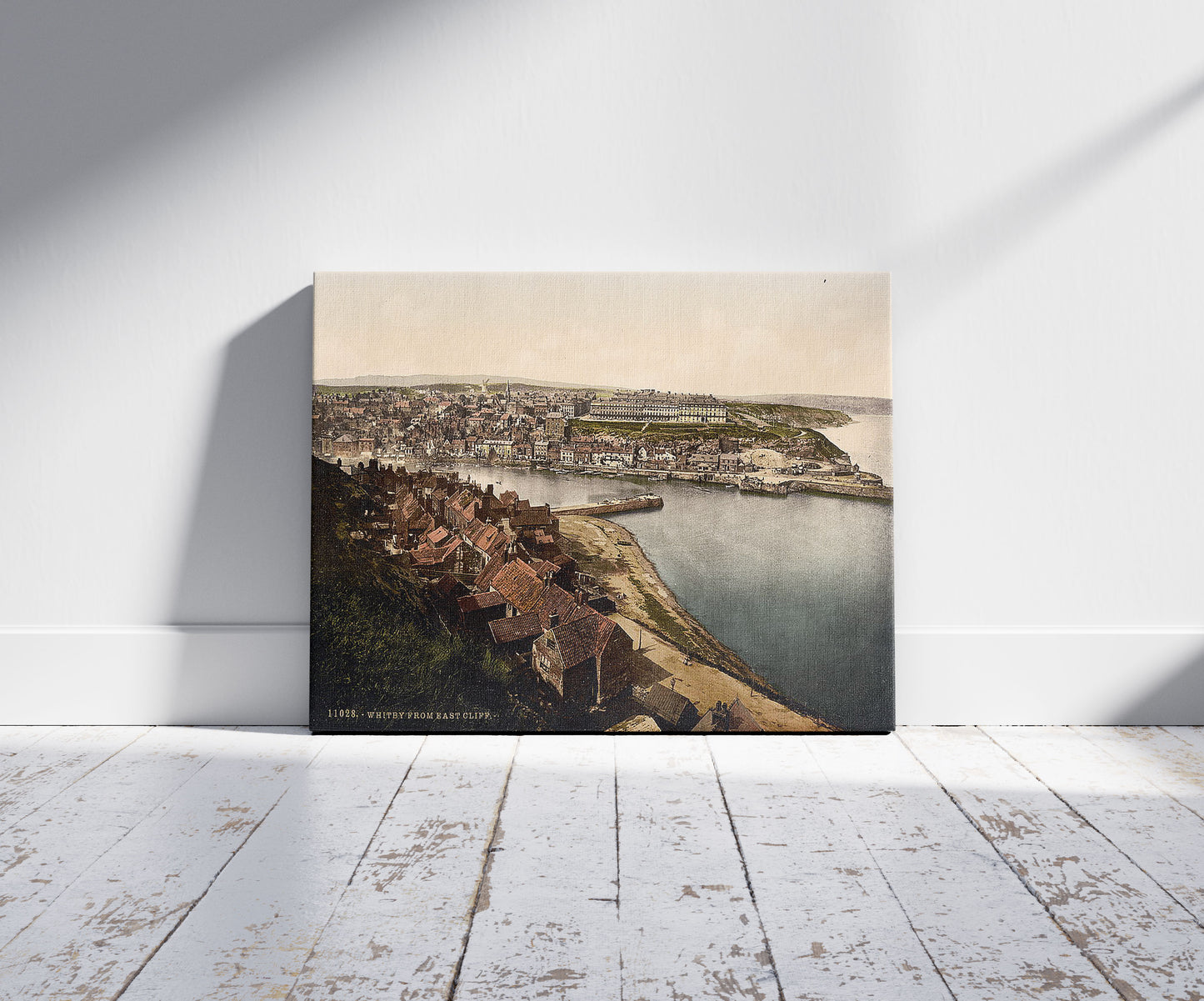 A picture of Whitby, from East Cliff, Yorkshire, England, a mockup of the print leaning against a wall