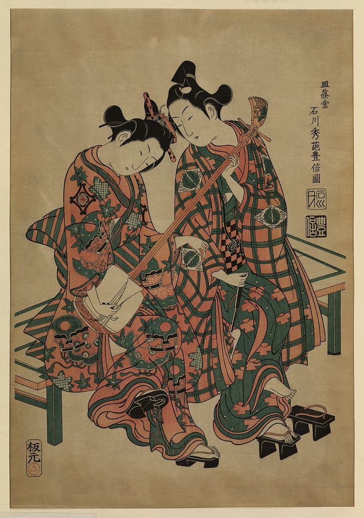 A picture of Two musicians seated on a bench, wearing geta